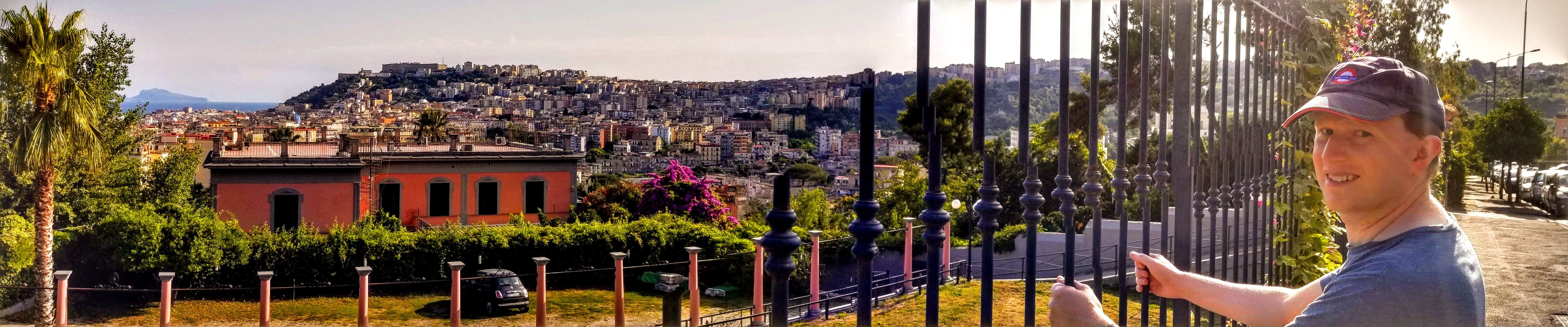 A man gripping metal bars overlooking Naples, Italy.