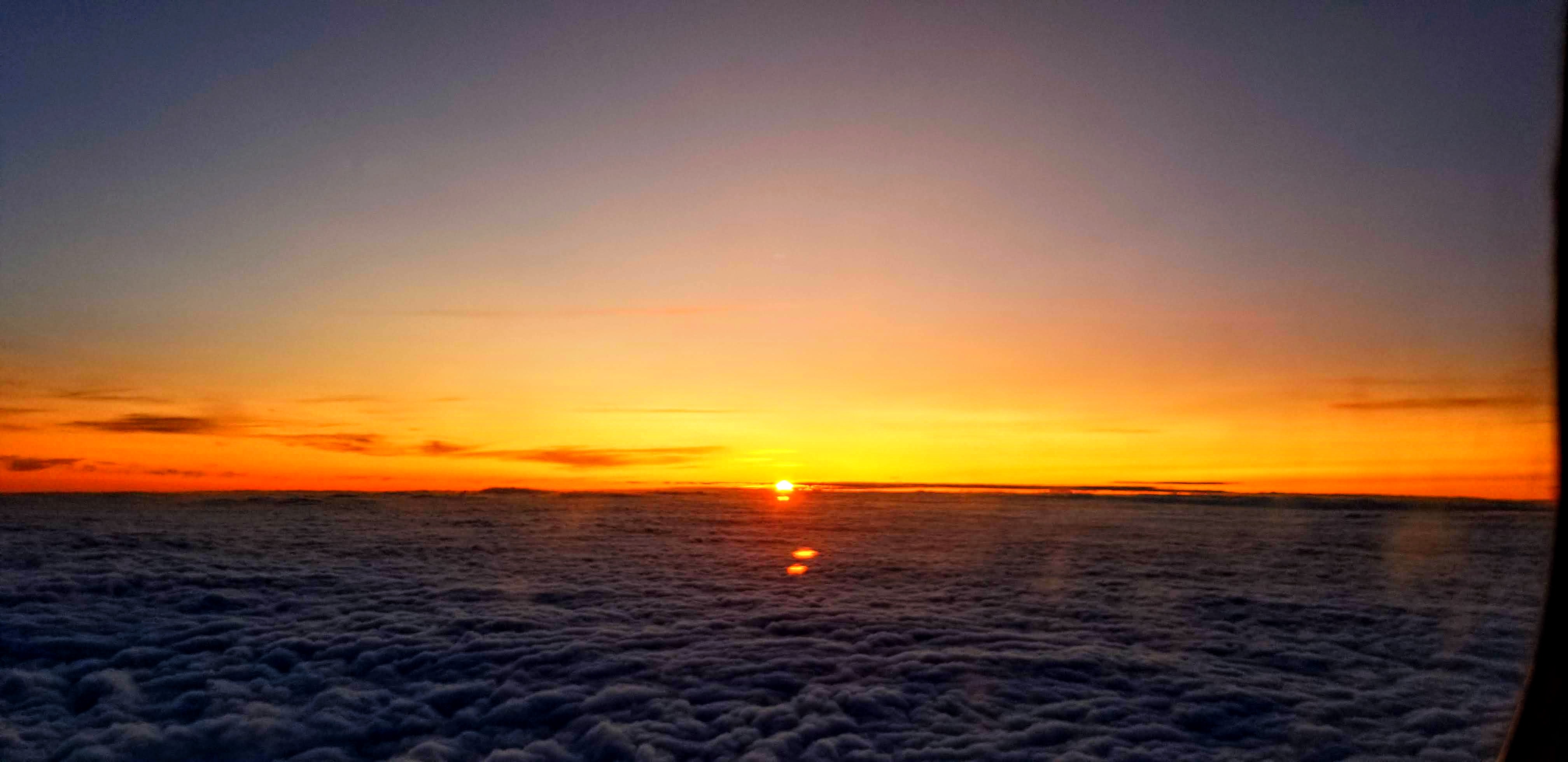 Sunset above clouds seen from the air.
