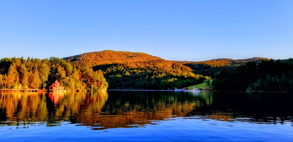 Photograph of a waterscape at sunset with a small boat.