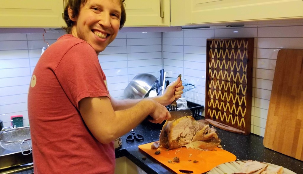 Photo of a man carving a turkey.