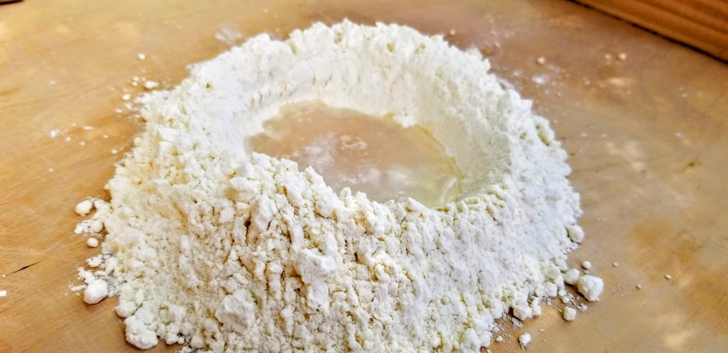 Photograph of flour and water mixing in preparation for making pasta.