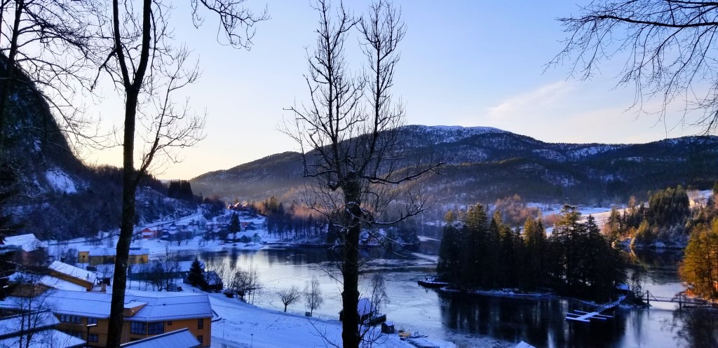 A mountain above a fjord just before the sun comes up.